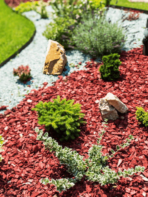 A landscape planter bed was created and covered with mulch chips and crushed rock.
