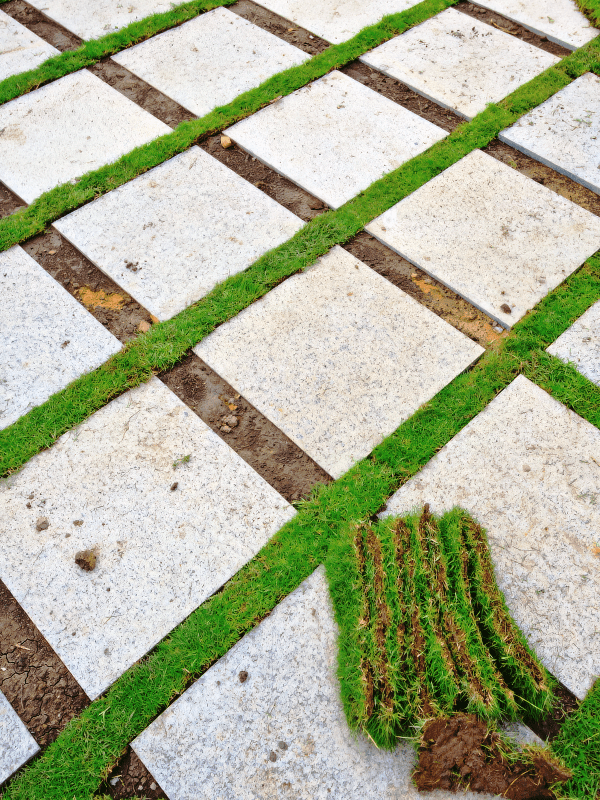 The patio is getting installed with stepping stones placed diagonally with grass in between