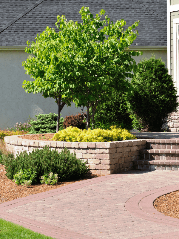 Paver pathway and retaining wall planter built with stone blocks