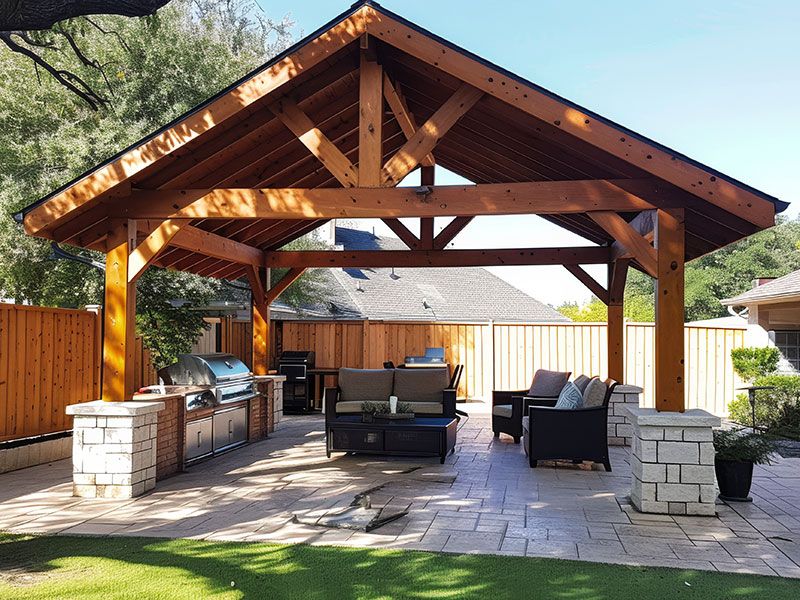 Cedar Pergola with Stone Footer Columns and Outdoor Kitchen - Perfect Backyard Oasis for Entertaining